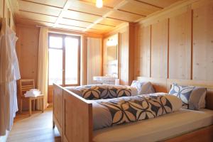 Wergenstein魔羯酒店餐厅的一间带两张床铺的卧室,位于带木墙的房间内