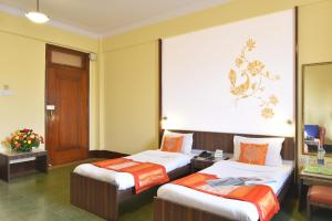 孟买大海绿色酒店 的酒店客房带两张床和一面墙