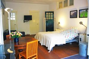 鹿特丹瓦尔恩贝格住宿加早餐酒店的一间卧室配有一张床、一张桌子和一张桌子