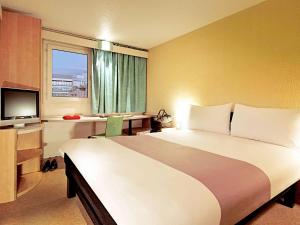 卡莱尔卡莱尔宜必思城市中心酒店的酒店客房设有一张大床和一台电视。