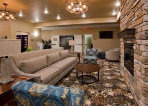 Valley CityGrandStay Hotel & Suites Valley City的客厅配有沙发、椅子和壁炉