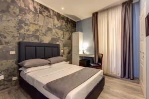 罗马贝利公寓酒店的一间卧室配有一张带蓝色墙壁的大床