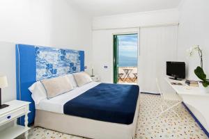 康加德马里尼里特拉切酒店的一间卧室配有一张床、一张书桌和一个窗户。