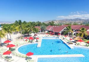 蒙特鲁伊斯英迪戈得可麦仑皇家酒店 - 全包的享有带椅子和遮阳伞的度假村游泳池的空中景致