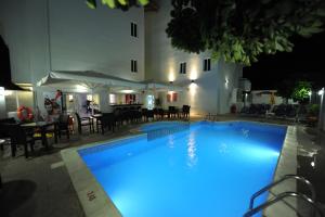 伊利索斯Ialysos City Hotel的大楼前方的大型游泳池,有蓝色的灯光