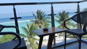 胡鲁马累维斯塔海滩休憩酒店的海滩景阳台配有桌椅