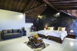 乌鲁瓦图14号棕榈树酒店的一间卧室设有两张床和砖墙