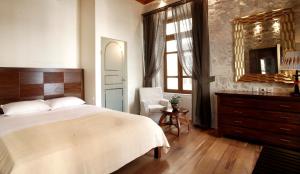 罗希姆诺狮子座酒店的一间卧室配有一张床、一把椅子和镜子