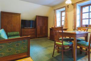 什平德莱鲁夫姆林滨海公寓的客厅配有桌椅和电视。