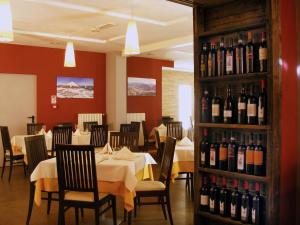 法申Hotel Dolomiti Chalet的用餐室配有桌子和瓶装葡萄酒
