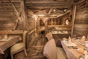 摩德纳迪-坎皮格里奥浪漫广场体育酒店的餐厅拥有木墙和桌椅