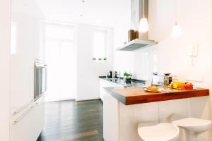 巴登-巴登Deluxe Apartments LWP7的厨房配有白色橱柜和木制台面