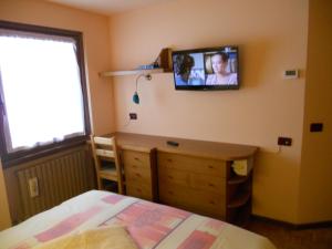 瓦尔富尔瓦帕奥拉旅馆的卧室配有一张床,墙上配有电视。