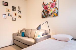 鲁汶鲁汶门户一室公寓的卧室配有沙发,墙上挂着牛油画