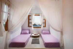 林都斯Lindos Seaside Villa的配有窗帘和窗户的客房内的两张床