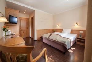 基希海姆艾夏霍夫酒店的酒店客房配有一张床、一张书桌和一台电视。