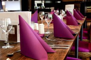 埃尔斯佩特斯塔肯贝格陆威酒店的一张桌子,上面有紫色餐巾和酒杯