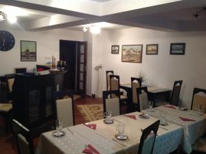 特尔古穆列什Pensiunea Kenza的用餐室配有桌椅和白色桌布