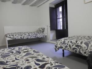 潘普洛纳Plaza Catedral hostel的一间卧室设有两张床和窗户。