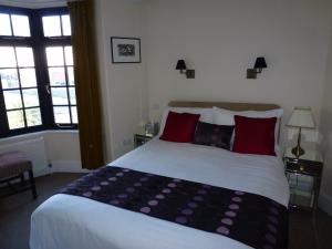 伊斯特布恩皇家酒店（仅限成人） 的一间卧室配有一张带红色枕头的大床