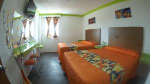 瓦乌奇南戈Hotel Yekkan的配有橙色床单的客房内的两张床