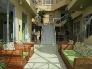 梅尔加Hotel Marux Plaza的大楼内的阳台设有藤椅和楼梯
