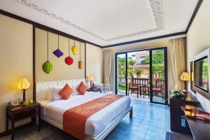 会安会安舒适别墅精品酒店的酒店客房设有一张床和一个阳台。