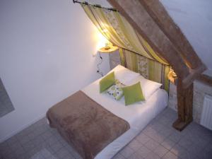 Bernières-sur-Mer吕泽尔恩宾馆的一间卧室配有一张带绿色枕头的床