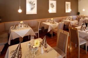 雷西亚Hotel Am Reschensee的餐厅配有桌椅和白色的桌布