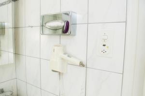 普拉特恩祖尔赛琳娜宾馆的白色瓷砖浴室设有淋浴和牙刷
