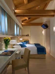 泰塞拉威尼斯机场安尼亚公园酒店的一间卧室配有一张床和一张桌子及椅子