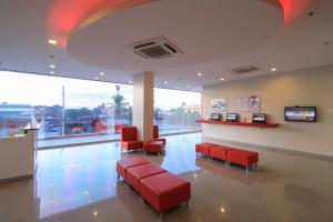 达沃市Red Planet Davao的一间设有红色椅子和电视的等候室