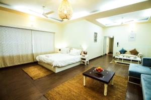 新德里安娜拉服务式公寓 - 格雷特凯拉什二期的一间卧室配有一张床、一张沙发和一张桌子