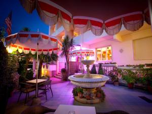 切齐纳码头塞里尼安东尼奥别墅酒店的一个带喷泉、桌子和遮阳伞的庭院