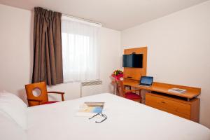 波尔多波尔多伊瑟尔公园及套房酒店的酒店客房配有一张床、一张书桌和一台笔记本电脑