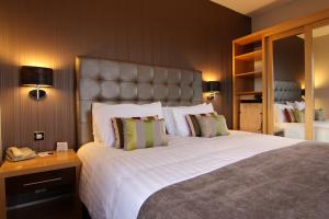 伦敦德里城市酒店的一间卧室配有一张大床和一部电话