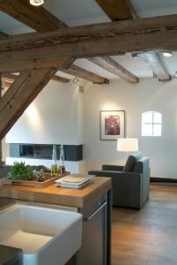奥德斯希尔德Texel Suites的厨房和客厅设有木制天花板。