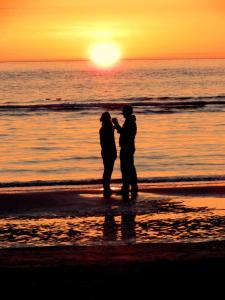 斯希蒙尼克奥赫Dune Bep的日落时分两人站在海滩上