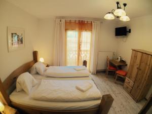 上特劳恩哈尔施塔特湖滨酒店的一间卧室设有两张床、一张桌子和一个窗口。