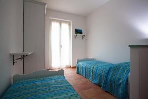 Gli AngeliVenticello Del Conero的一间卧室设有两张床和窗户。
