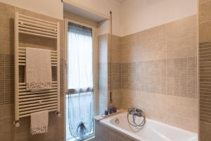 罗马台伯河岸区艾玛之家公寓的带浴缸、水槽和窗户的浴室