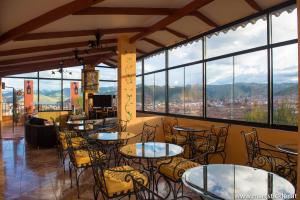 库斯科夸尔卡姆帕塔旅馆的餐厅设有桌椅和大窗户。