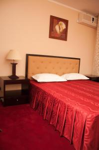 克勒拉希Hotel Baden的酒店客房,配有一张红色床罩的床