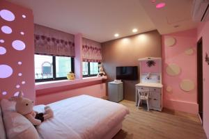 花莲市Fasiter B&B train station的粉红色的卧室,配有一张带泰迪熊的床