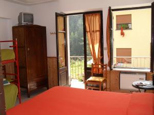 Salza di PineroloLa Miando Rooms的一间卧室设有一张床和一个阳台的窗户。