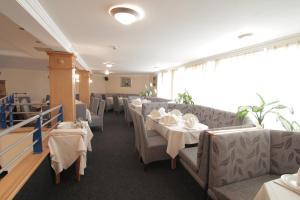 克鲁舍瓦茨高尔夫酒店的用餐室配有桌椅和白色的桌子床单