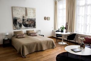 马斯特里赫特迪斯画廊酒店的卧室配有一张床和一张桌子及椅子