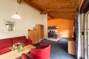 大舍瑙Trixi Ferienpark Zittauer Gebirge的客厅配有红色的沙发和桌子