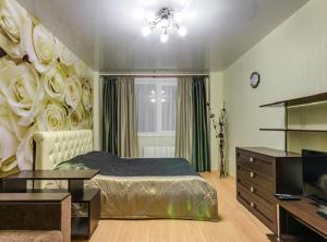 沃罗涅什ATLANT Apartments 106的一间卧室,配有一张带玫瑰墙的床