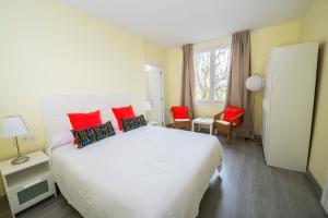 卡萨拉雷纳欧雅山谷酒店的卧室配有带红色枕头的大型白色床